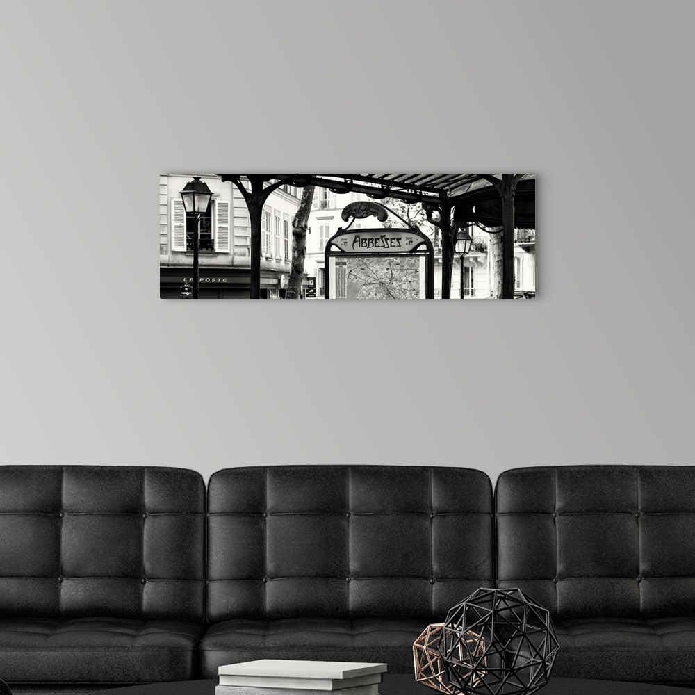 A modern room featuring A black and white photograph of the Abbesses subway station sign in Paris.