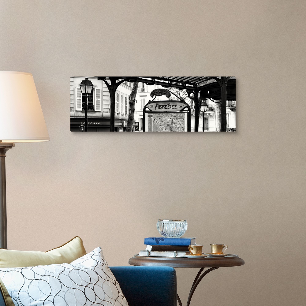 A traditional room featuring A black and white photograph of the Abbesses subway station sign in Paris.