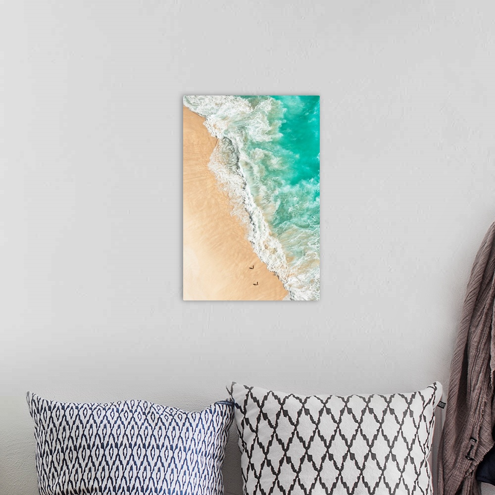 A bohemian room featuring A stunning overhead aerial photograph of bright turquoise waves crashing onto a sandy beach wth t...
