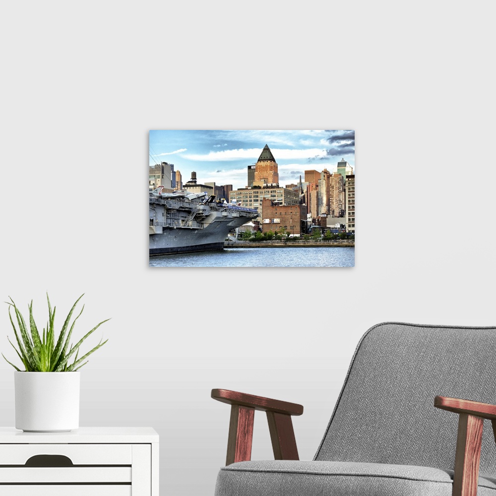 A modern room featuring Fine art photo of a large military ship in New York harbor.