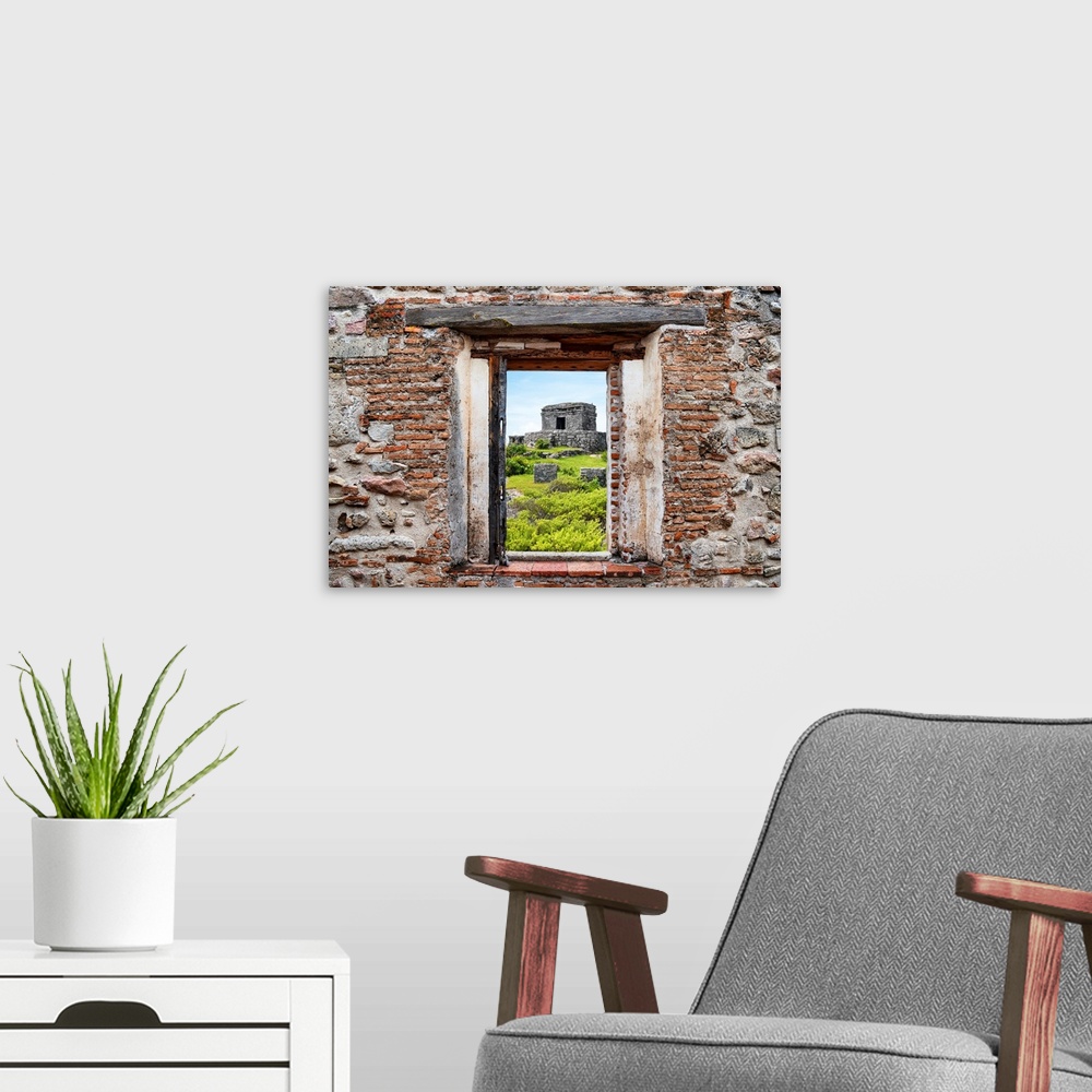 A modern room featuring View of the ancient Mayan fortress in Tulum, Mexico, framed through a stony, brick window. From t...