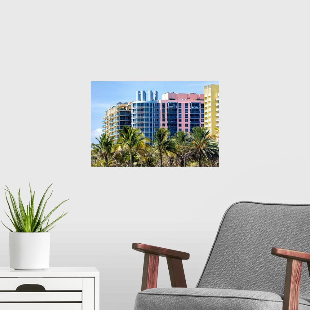 A modern room featuring Multi colored buildings behinda row of palm trees in Miami, Florida.