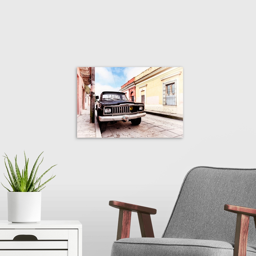A modern room featuring Washed out photograph of an old black Jeep parked on the side of a colorful street in Mexico. Fro...