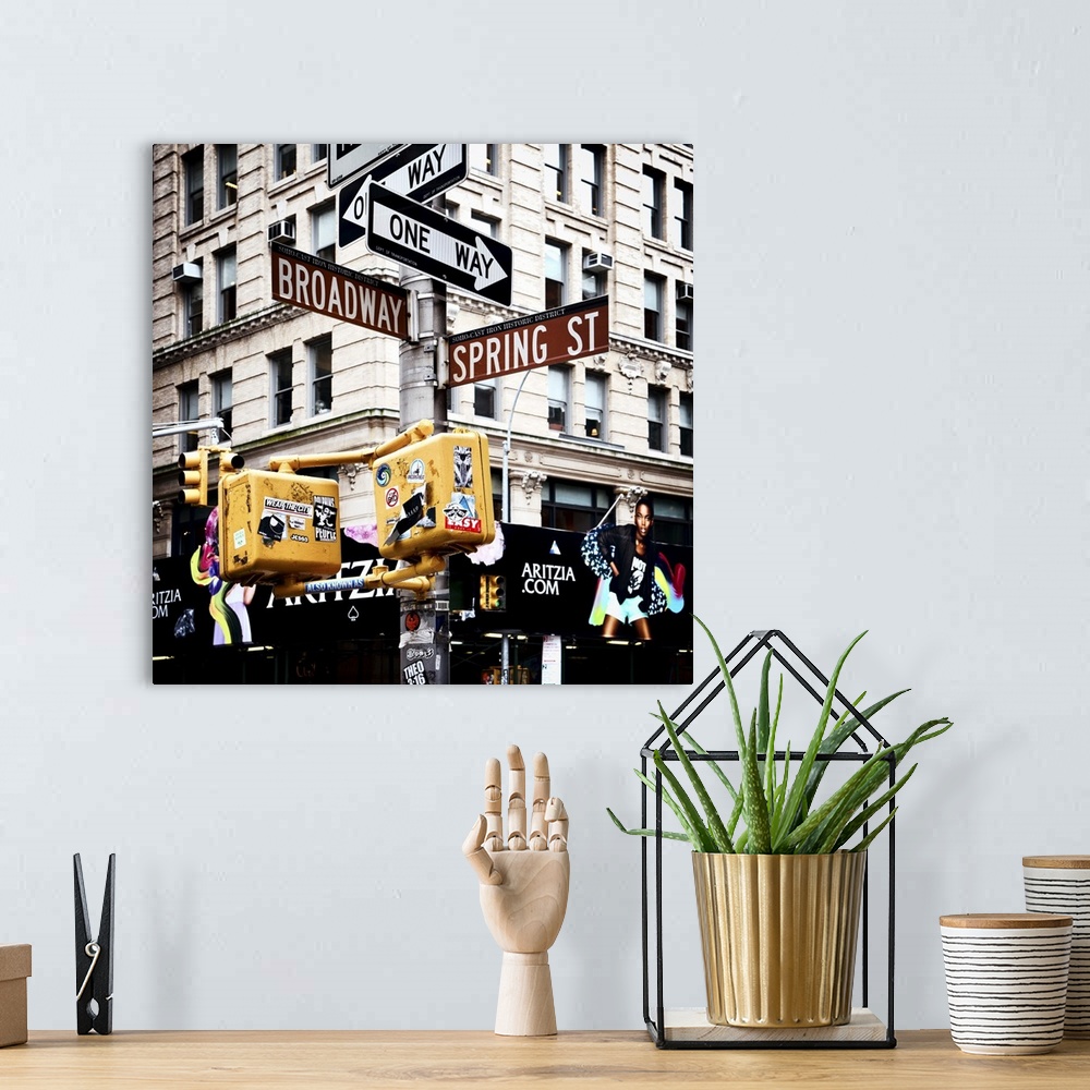 A bohemian room featuring Post with one way signs and Broadway and Spring Street signs, with stickers and graffiti on the l...
