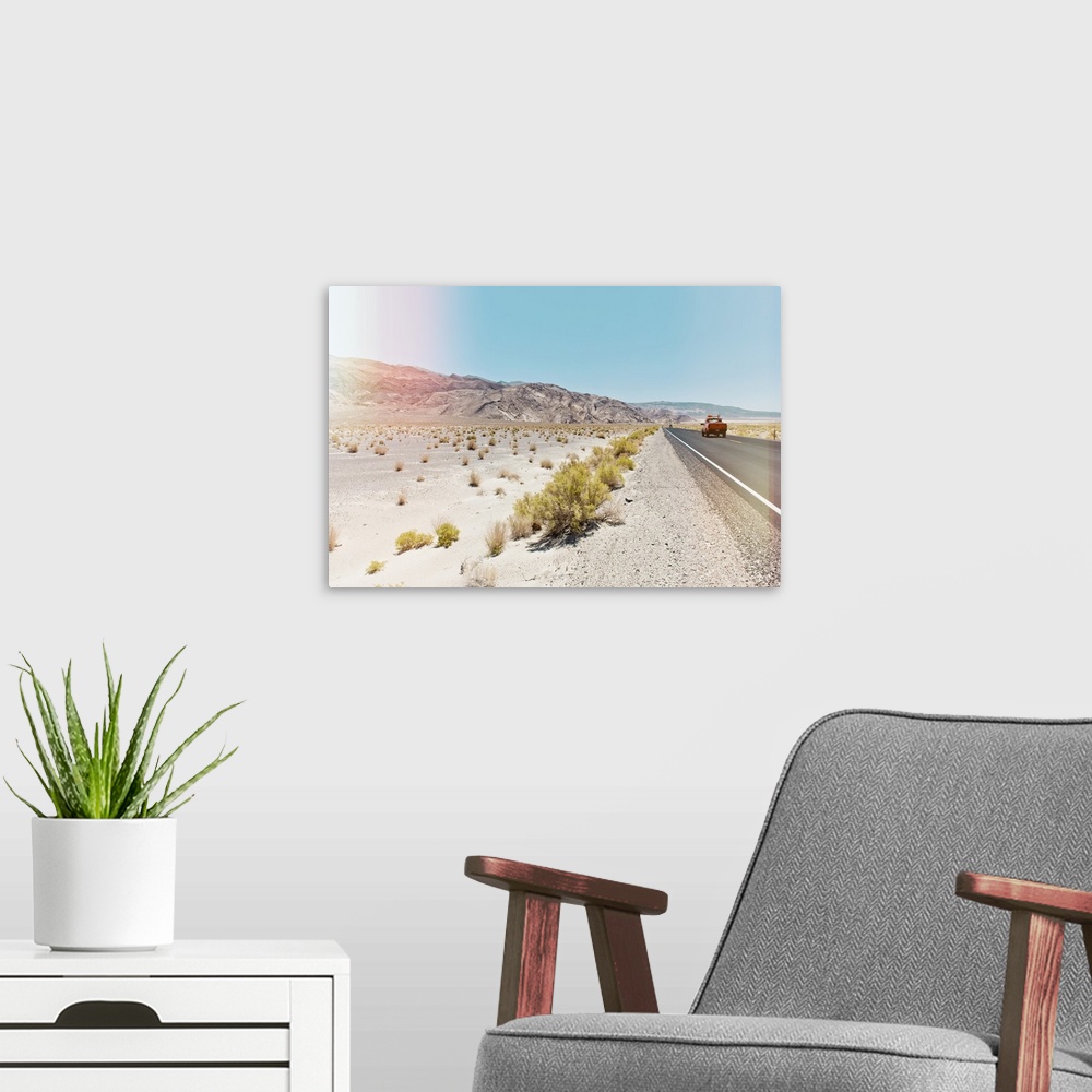 A modern room featuring A photograph in soft faded pastel colors of a desert landscape in California.