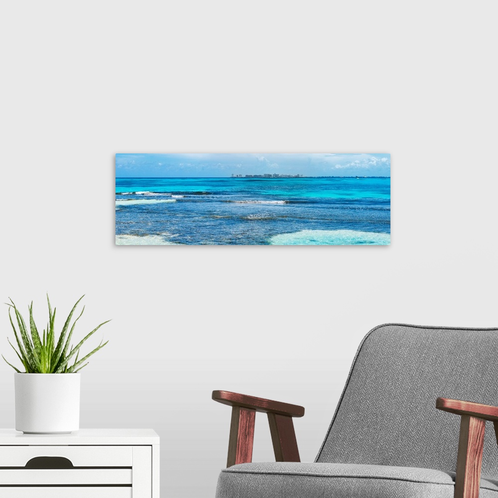 A modern room featuring Panoramic photograph of the clear blue Caribbean ocean with the Cancun skyline in the background....
