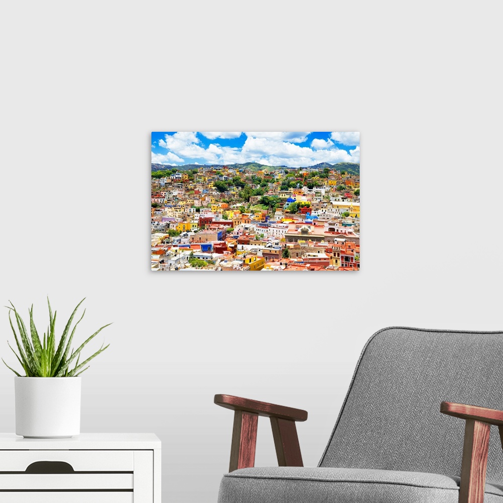A modern room featuring Aerial photograph of the city of Guanajuato, Mexico, with colorful buildings and mountains in the...