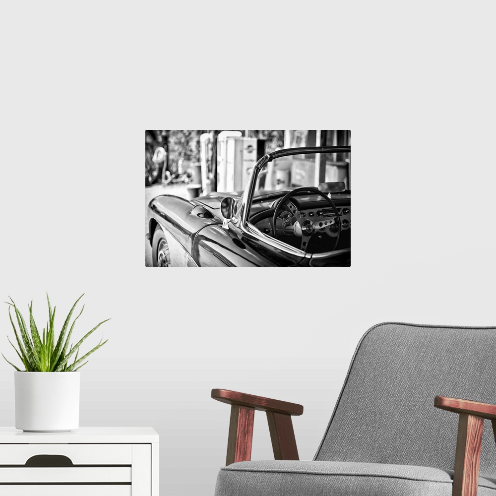 A modern room featuring Black and white photograph of a classic Chevy convertible on the beach.