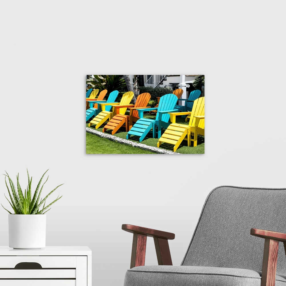 A modern room featuring A collection of brightly painted Adirondack chairs.