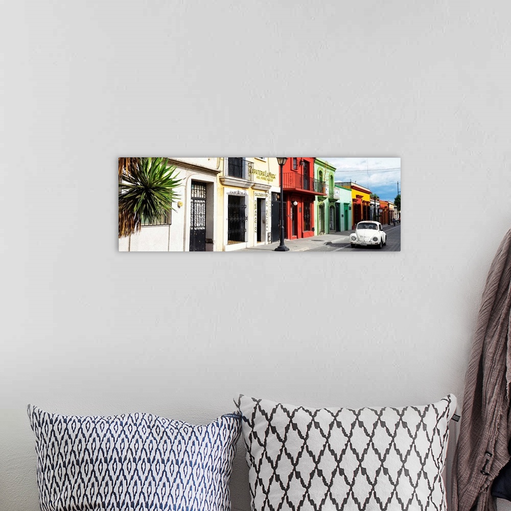 A bohemian room featuring Panoramic photograph of a classic white Volkswagen Beetle driving up a colorful street in Mexico....