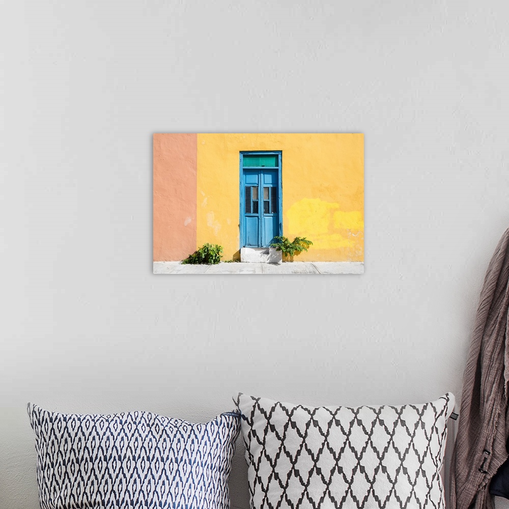 A bohemian room featuring Photograph of a pale yellow and pink exterior wall with a bright blue door off the street in Mexi...