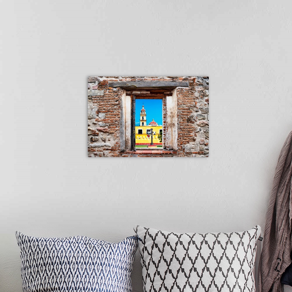 A bohemian room featuring View of a Courtyard of a Church in Puebla, Mexico, framed through a stony, brick window. From the...