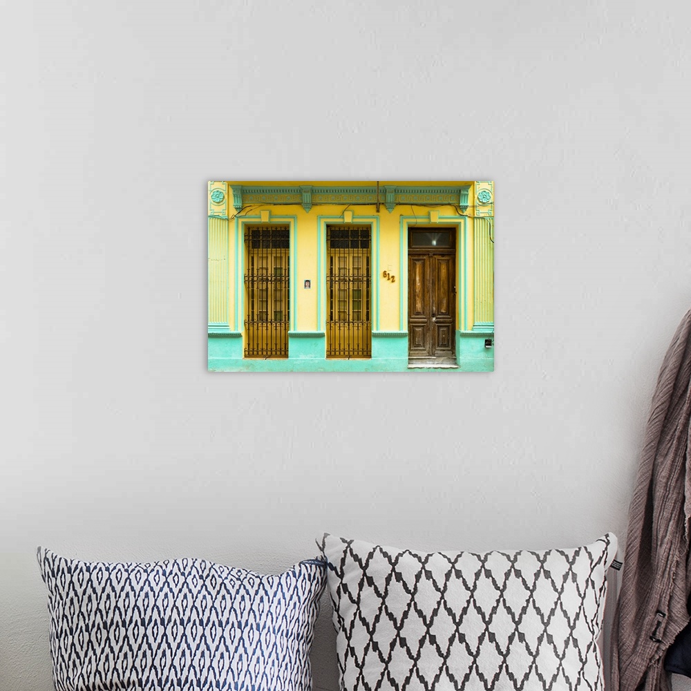 A bohemian room featuring Photograph of a turquoise and yellow building facade with two windows and a wooden door in Havana...