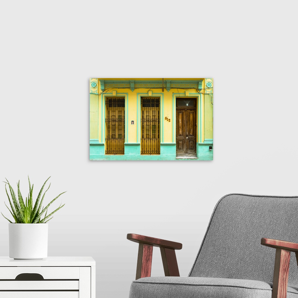 A modern room featuring Photograph of a turquoise and yellow building facade with two windows and a wooden door in Havana...