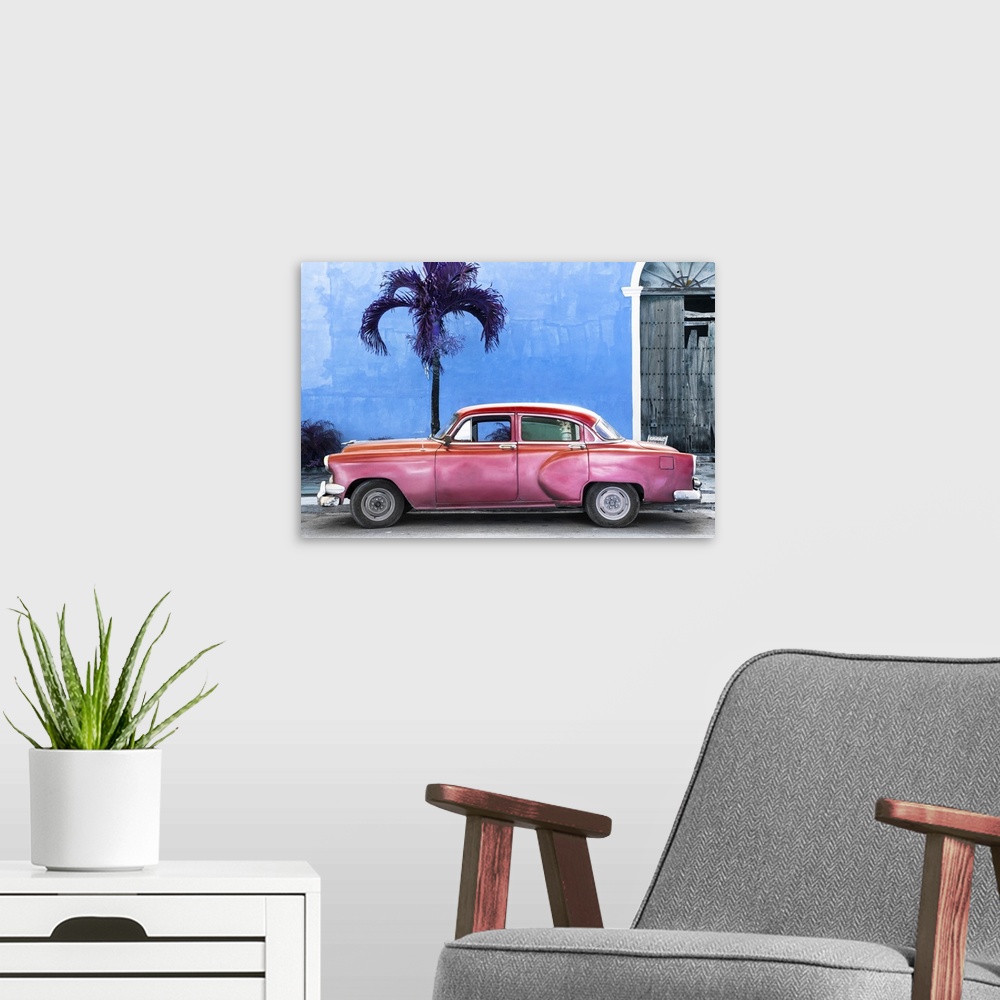 A modern room featuring Photograph of a pink vintage car parked outside of a blue building with a palm tree.