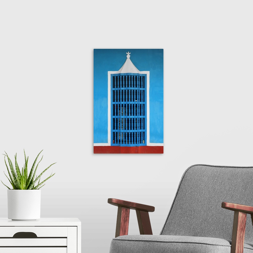A modern room featuring Photograph of a blue, white, and red facade with a decorative window in Havana.