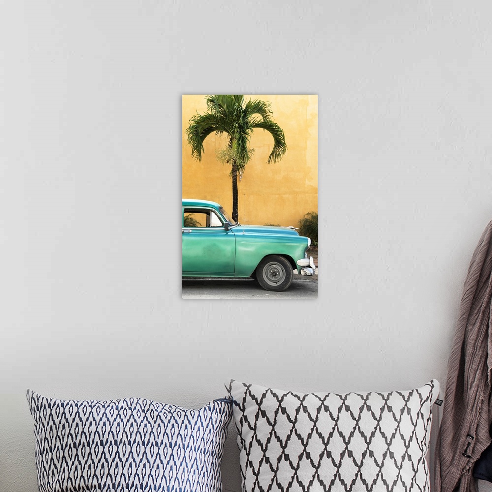 A bohemian room featuring Photograph of the front half of a vintage green car in front of a palm tree and an orange wall in...