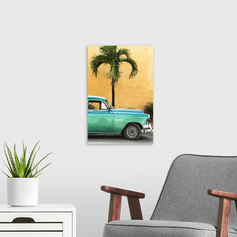 A modern room featuring Photograph of the front half of a vintage green car in front of a palm tree and an orange wall in...