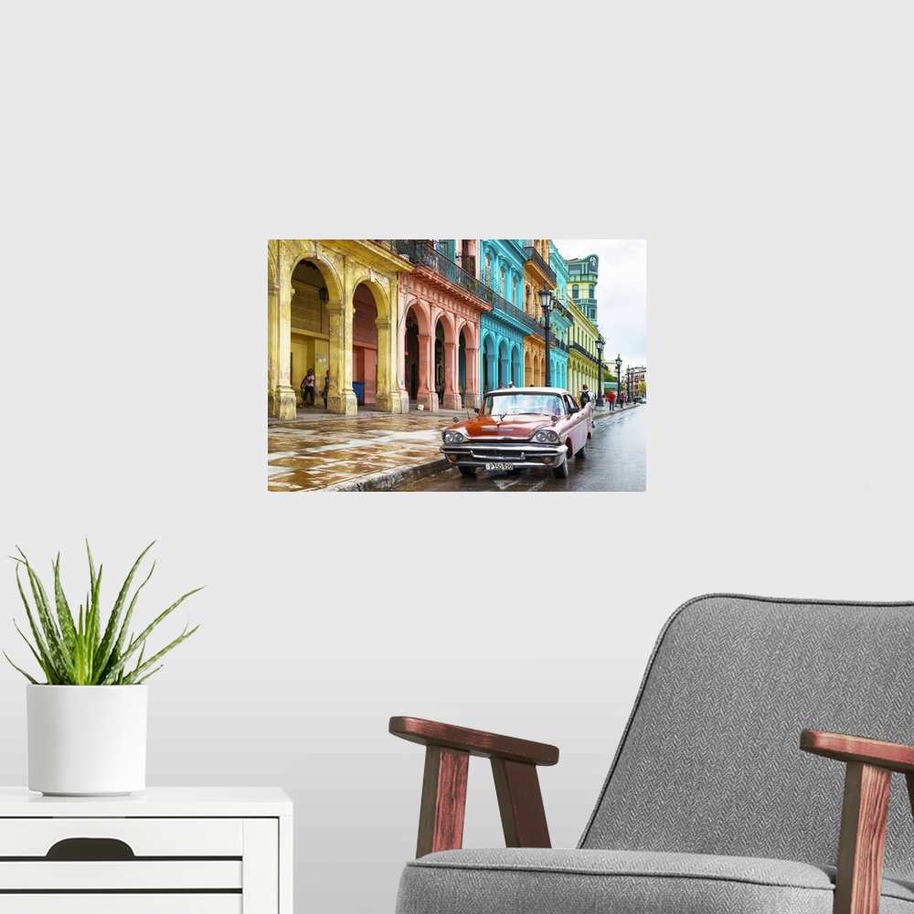 A modern room featuring Photograph of a red vintage car parked outside of a colorful building facade in Havana, Cuba.