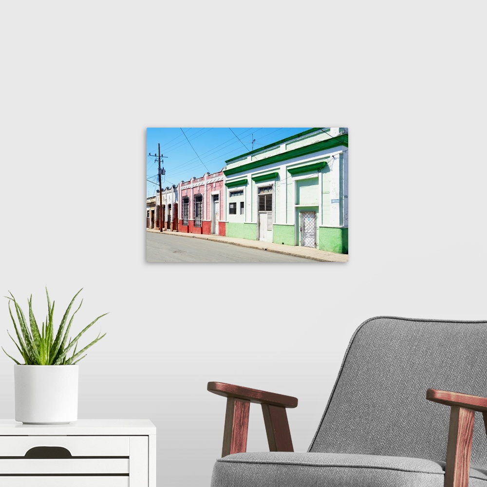 A modern room featuring Photograph of a Havana streetscape with colorful facades lining the road.