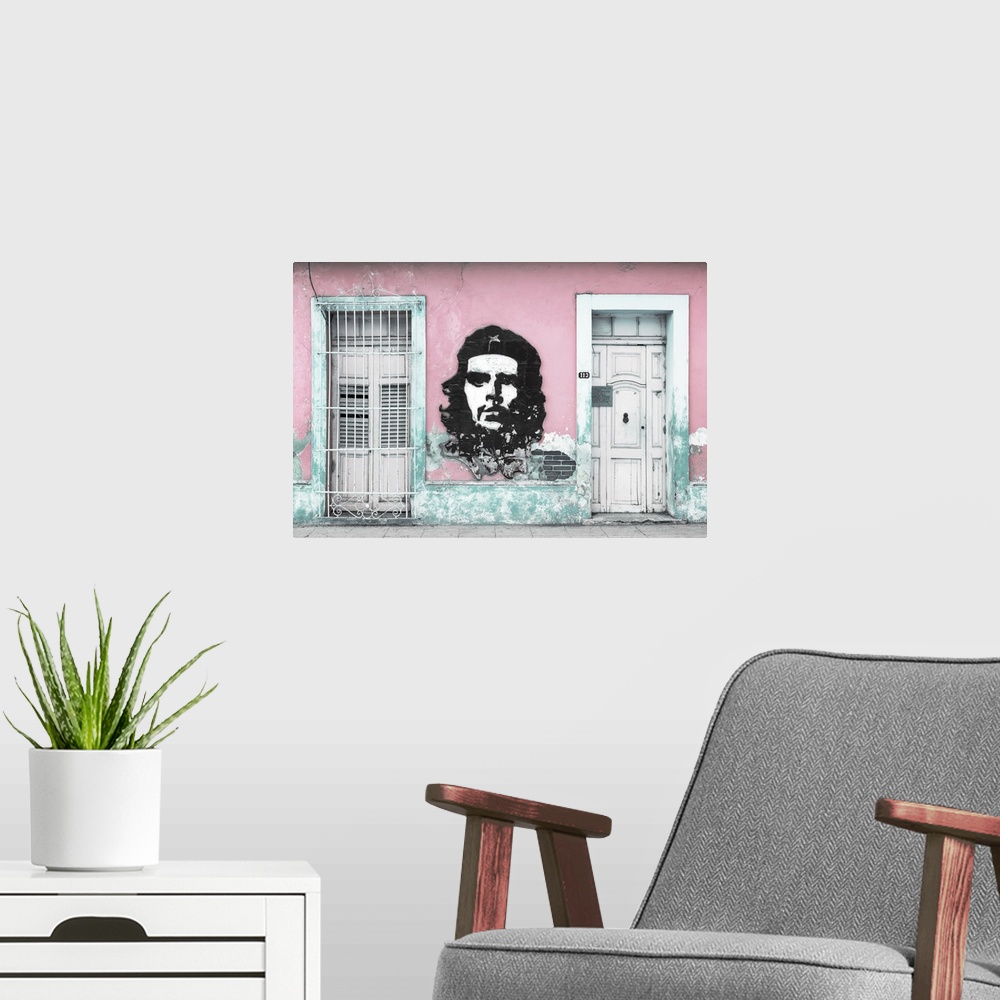 A modern room featuring Photograph of a Cuban facade with Che Guevara painted in between a window and a door on a pink wall.