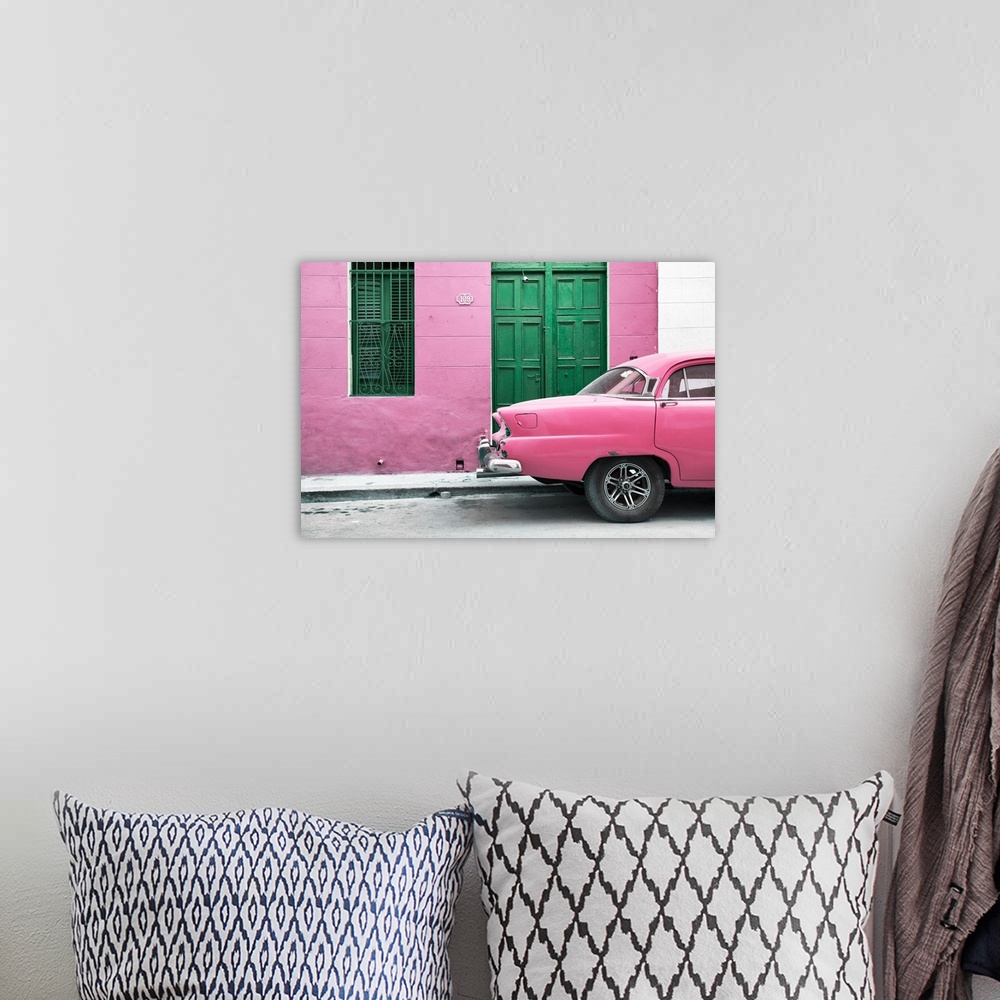A bohemian room featuring Photograph of the back of a pink vintage car next to a matching facade with a green wooden door a...
