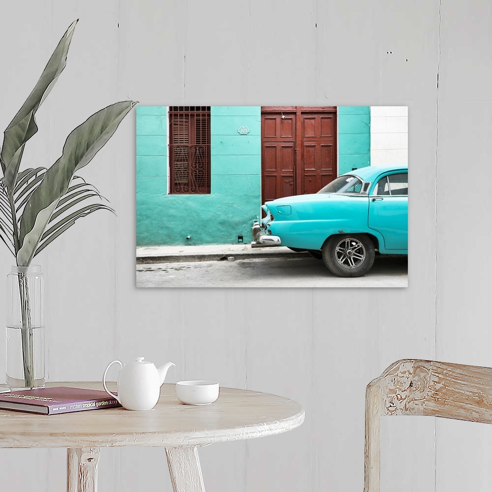 A farmhouse room featuring Photograph of the back of a turquoise vintage car next to a matching facade with a dark wooden do...