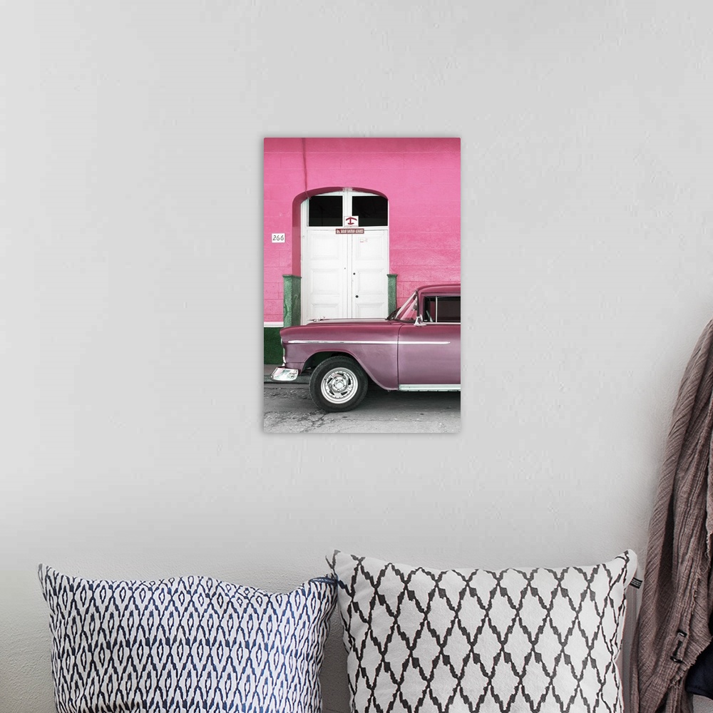 A bohemian room featuring Vintage pink car parked in front of a pink facade with a white door.