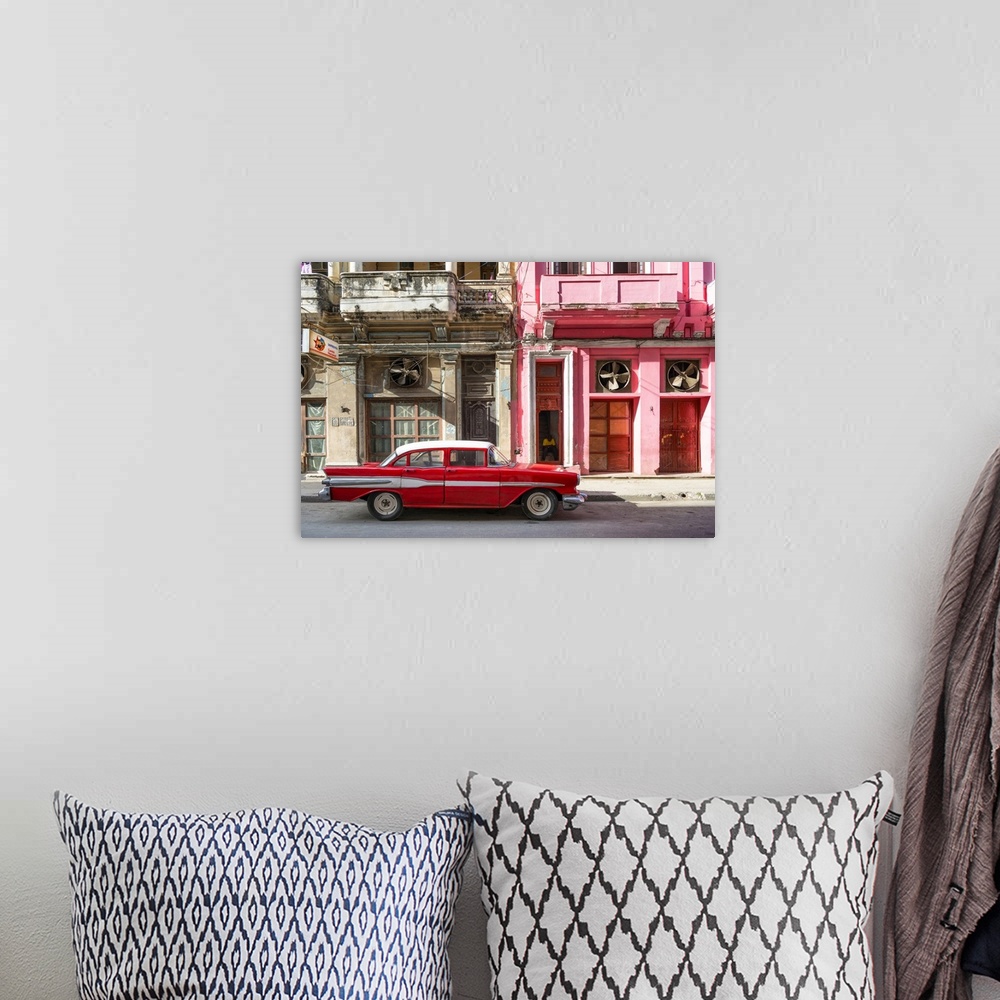 A bohemian room featuring Photograph of a red vintage car with white details parked in the street, Havana, Cuba