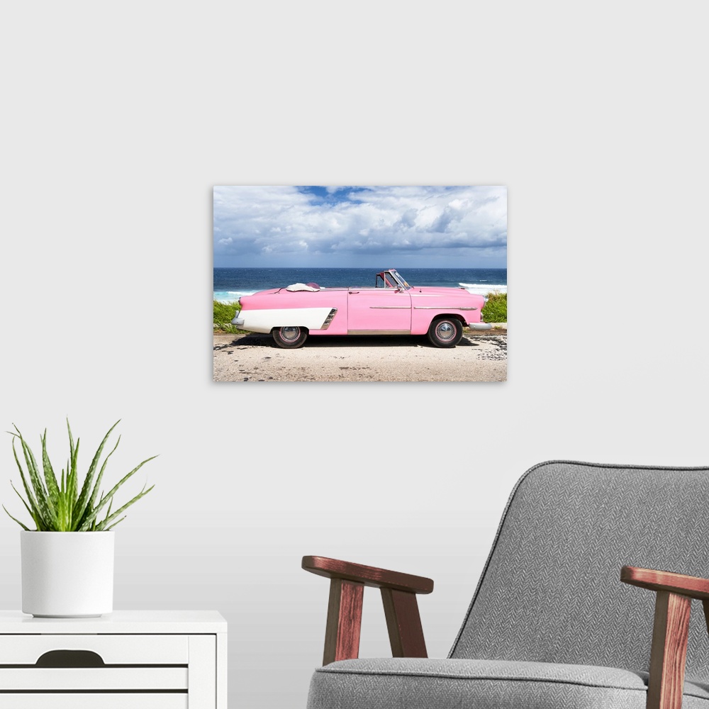 A modern room featuring Photograph of a light pink and white vintage convertible parked in front of the ocean.