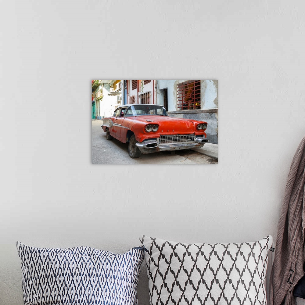 A bohemian room featuring Photograph of an old beat up red car parked on the streets of Havana.