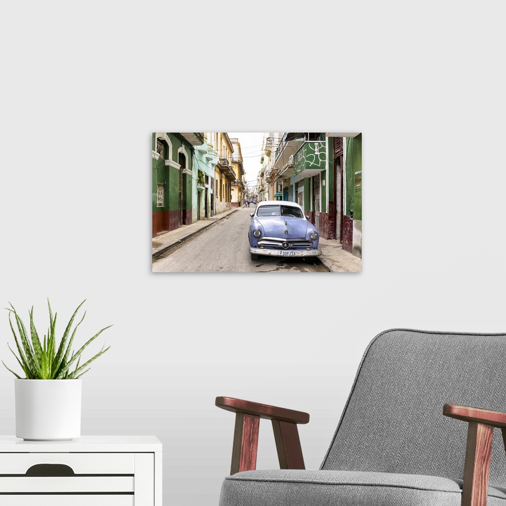 A modern room featuring Photograph of a blue vintage Ford car parked in a Havana street surrounded by buildings.
