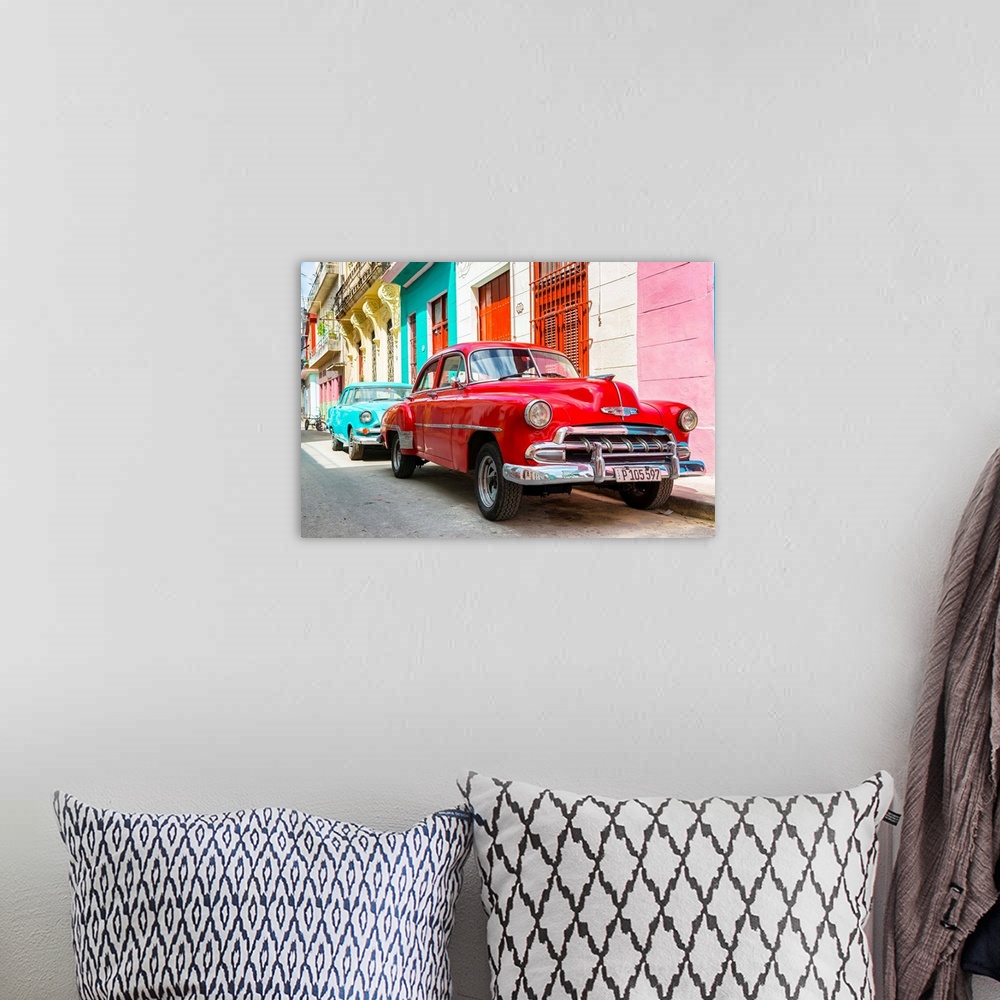 A bohemian room featuring Photograph of a turquoise and a red vintage Chevrolets parked along a colorful Havana street scene.
