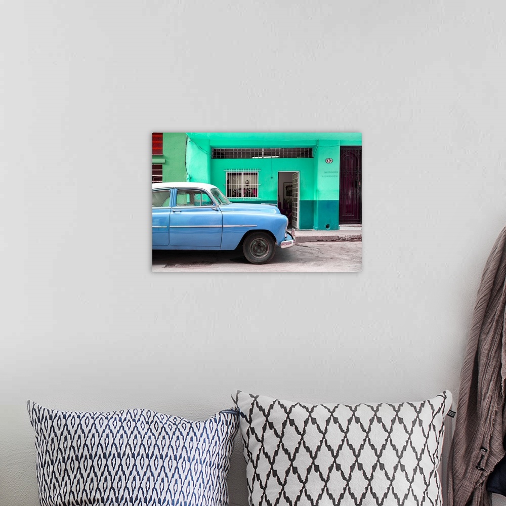 A bohemian room featuring Photograph of a blue vintage car parked on the road in Havana.