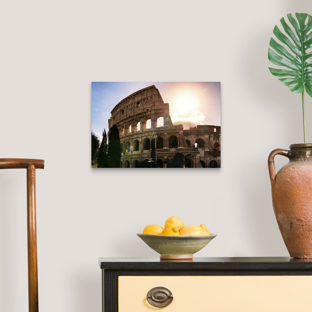 A traditional room featuring It's a view of the Colosseum at sunset in the centre of the city of Rome, Italy.