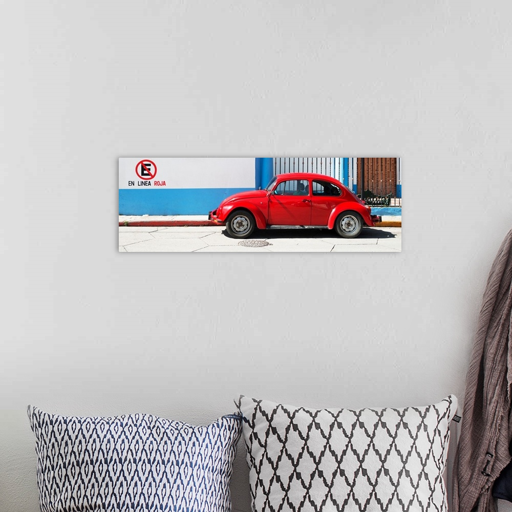 A bohemian room featuring Panoramic photograph of a red Volkswagen Beetle parked in front of a building with blueand white ...