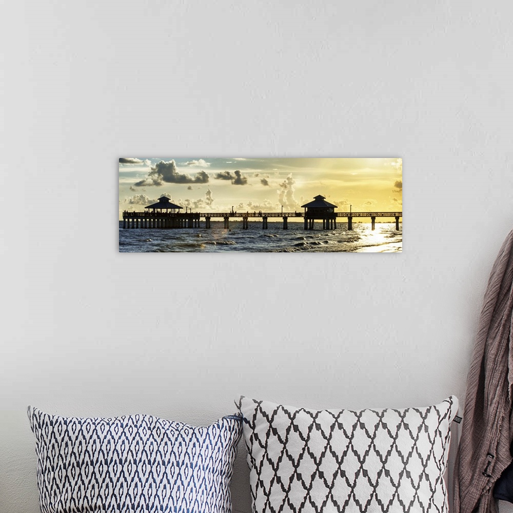 A bohemian room featuring Panoramic view of a silhouetted fishing pier at sundown in Florida.