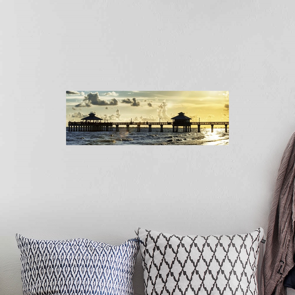 A bohemian room featuring Panoramic view of a silhouetted fishing pier at sundown in Florida.