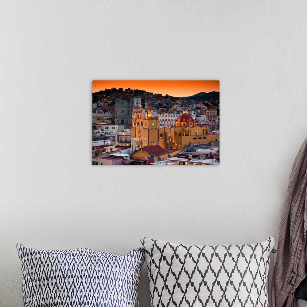 A bohemian room featuring Photograph of a Guanajuato cityscape featuring the iconic Yellow Church at twilight under orange ...