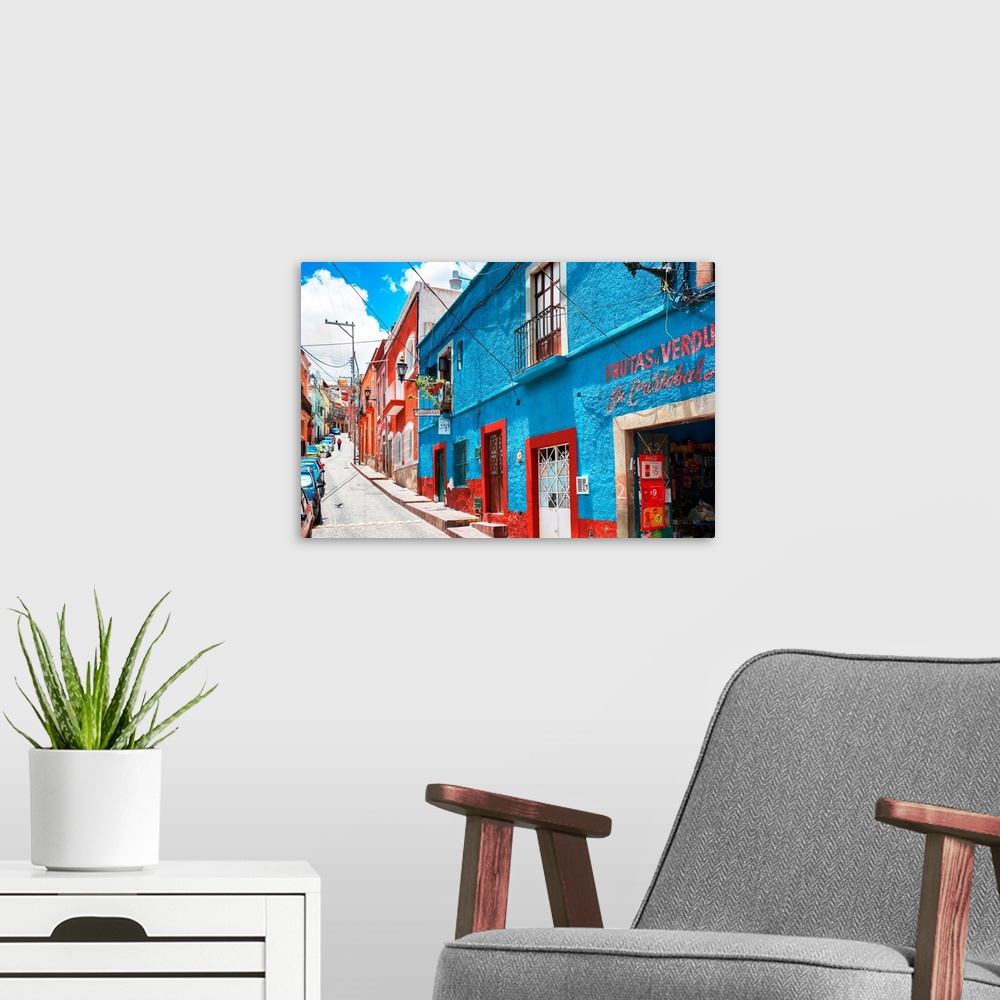 A modern room featuring Colorful streetscape photograph in Guanajuato, Mexico with bright blue and red buildings. From th...