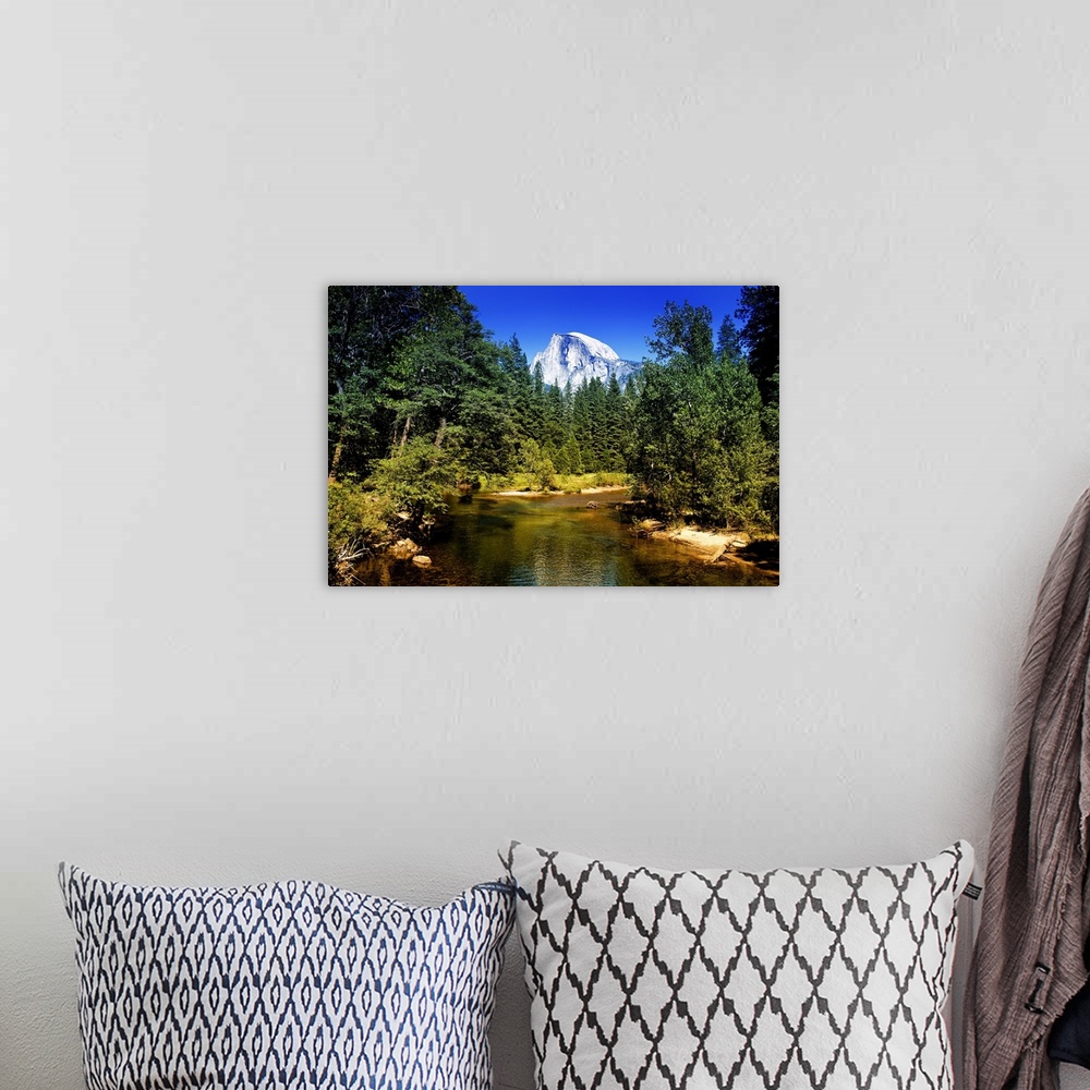 A bohemian room featuring The peak of Half Dome can be seen over the tops of pine trees in California's Yosemite National P...