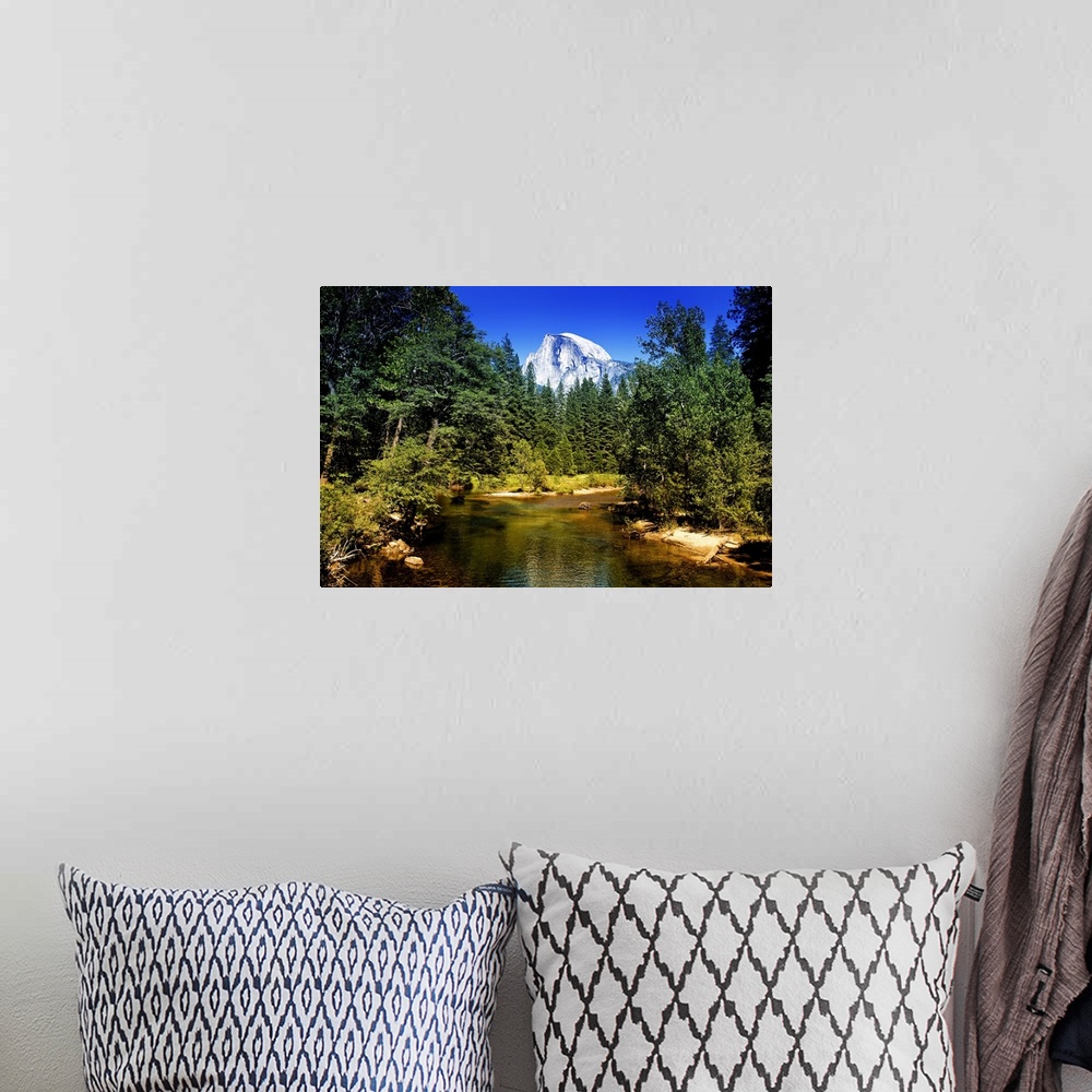 A bohemian room featuring The peak of Half Dome can be seen over the tops of pine trees in California's Yosemite National P...
