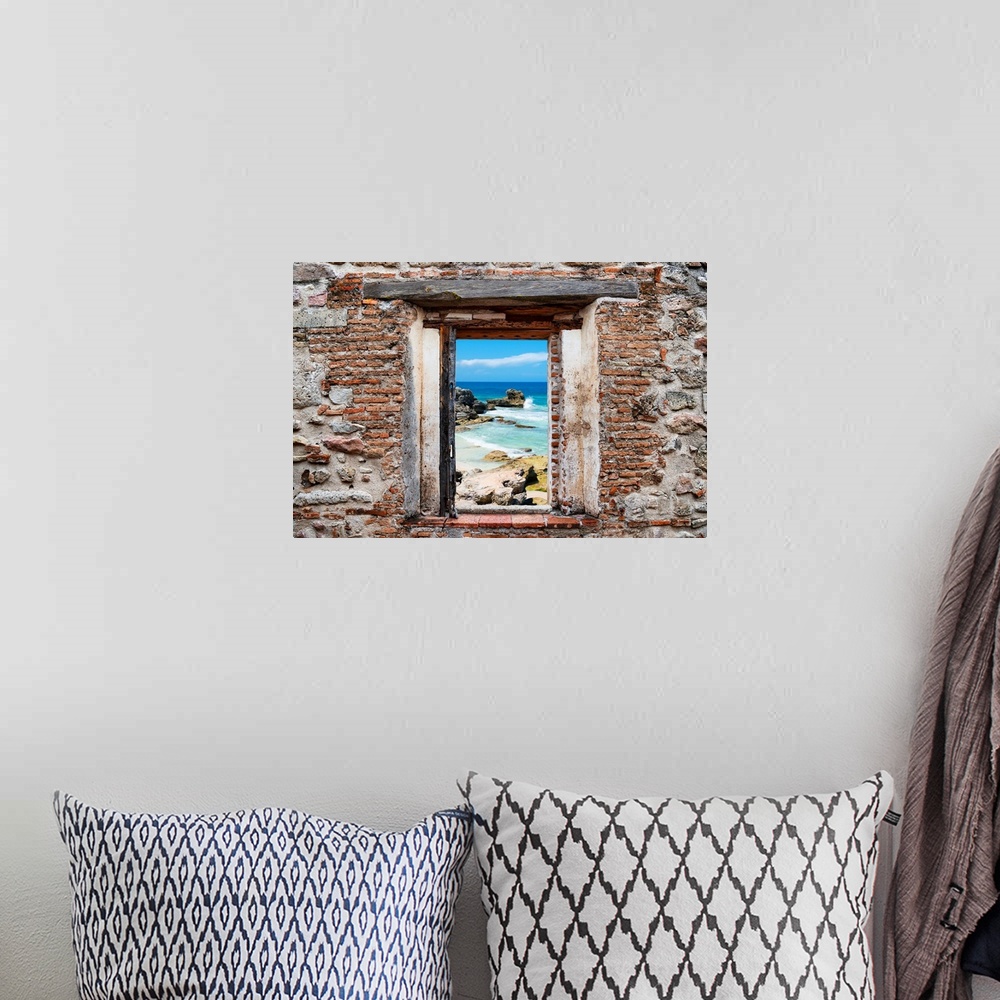 A bohemian room featuring View of the Isla Mujeres coastline framed through a stony, brick window. From the Viva Mexico Win...