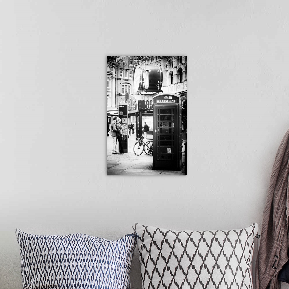 A bohemian room featuring A couple in love being passionate beside an iconic London telephone booth.