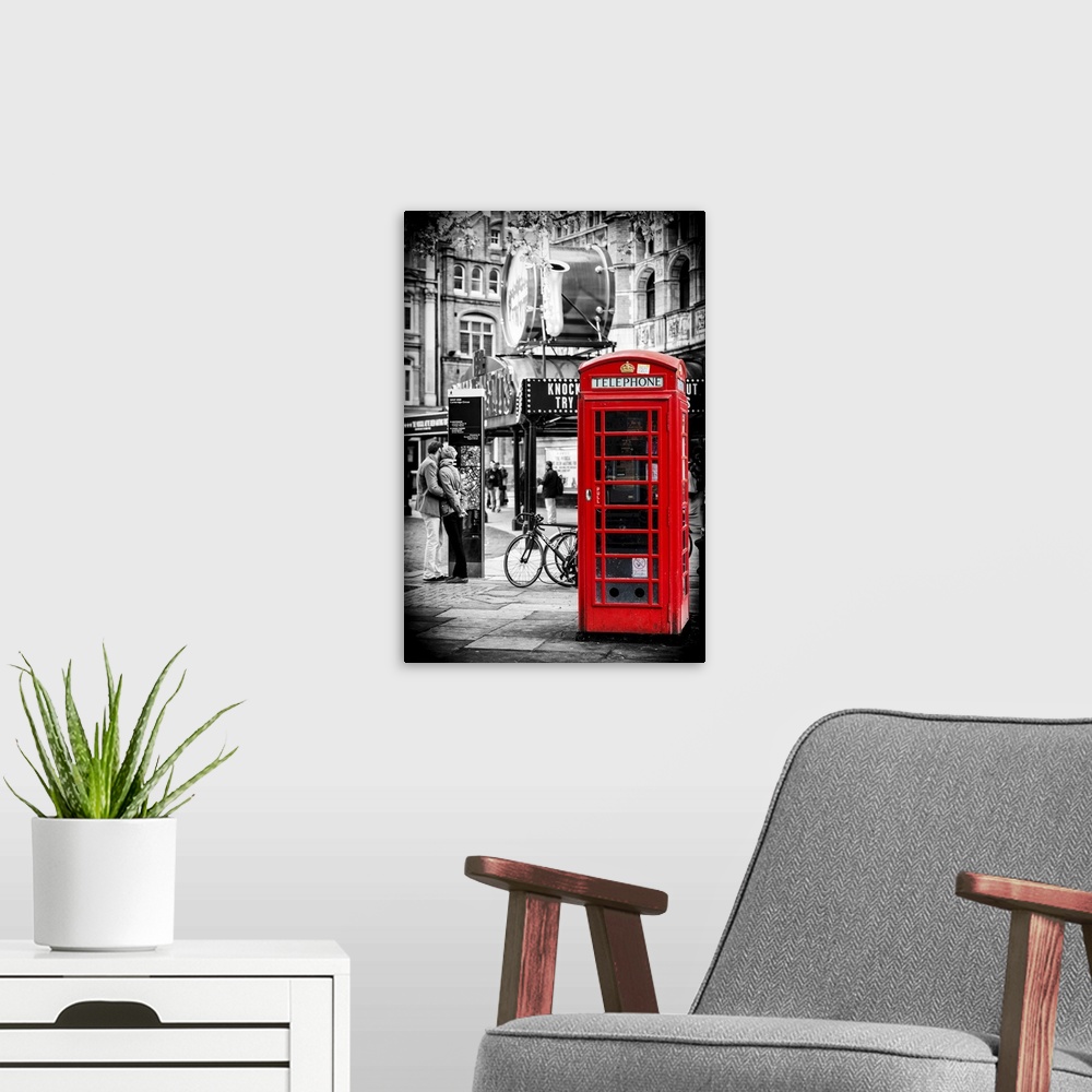 A modern room featuring A couple in love being passionate beside an iconic London telephone booth.