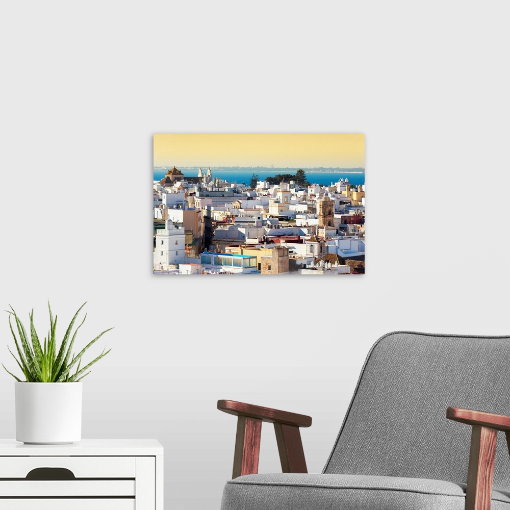 A modern room featuring It's a view of the buildings of the city of Cadiz in Spain at Sunset.