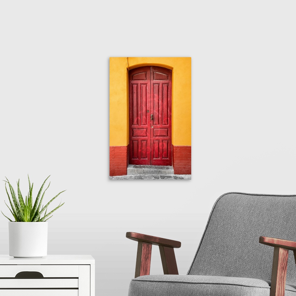 A modern room featuring It's an old red door in a street of Seville in Spain.