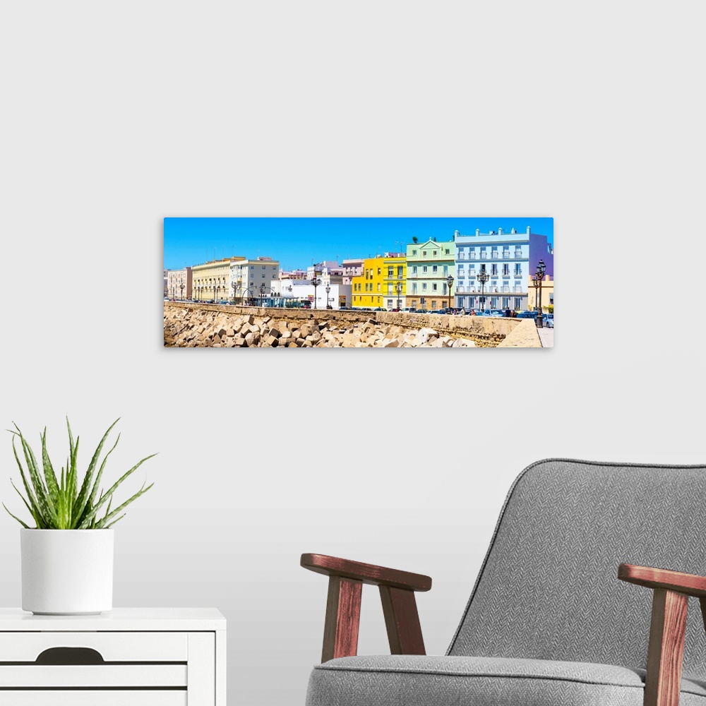 A modern room featuring These are the colorful buildings located in front of the seaside in Cadiz in Spain.