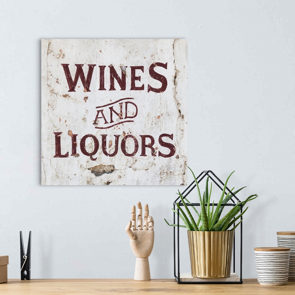 A bohemian room featuring It's a Wines and Liquors sign on an old wall, Spain.