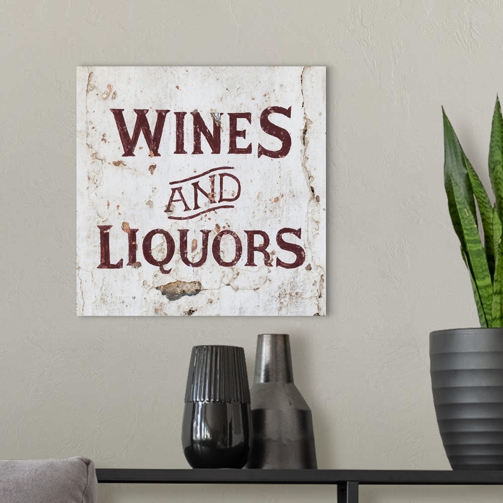 A modern room featuring It's a Wines and Liquors sign on an old wall, Spain.